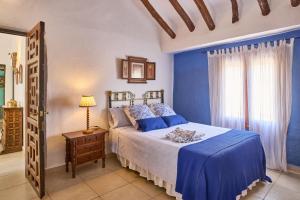 a blue bedroom with a bed and a window at Cortijo Las Gregorias in Lucena +33 photos