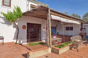 a porch of a white house with a bench at Cortijo Las Gregorias in Lucena