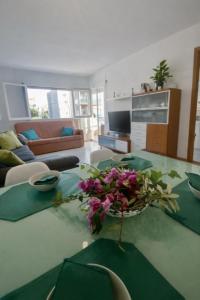 a living room with a table with a vase of flowers on it at Tramuntana apart in Calafell