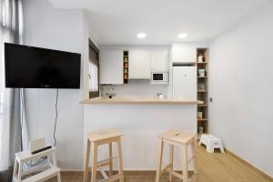 a living room with a tv and two stools at Alfons I in Puigcerdà