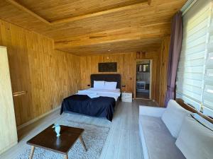 a bedroom with a bed and a couch at pınar kır evi in Artvin