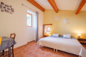 a bedroom with a bed and a window at Perles De Aime in Laurac-en-Vivarais