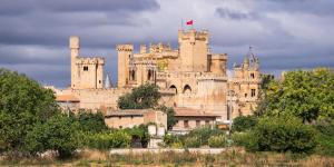 a large castle with a flag on top of it at Hotel Villa De Cárcar in Cárcar