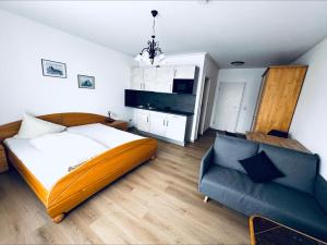 a bedroom with a bed and a couch and a chair at Pension Marcus in Bad Gögging