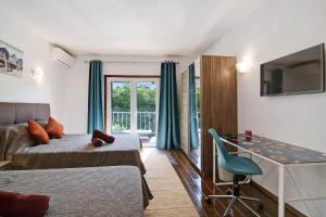 a bedroom with a bed and a desk and a tv at Hanna's Sunny Apartment in Albufeira