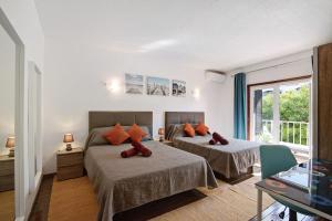 a bedroom with two beds and a balcony at Hanna's Sunny Apartment in Albufeira
