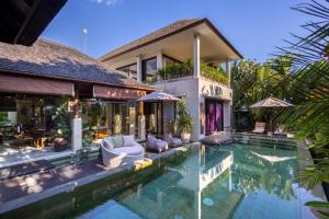 a house with a swimming pool in front of a house at Villa Sulastri - Tanah Lot in Tanah Lot
