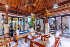 a living room with a couch and chairs at Villa Sulastri - Tanah Lot in Tanah Lot