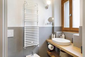 a bathroom with a white toilet and a sink at Villa Il Cortivo 81 in Fratta