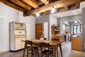 a kitchen with a wooden table and a refrigerator at Villa Il Cortivo 81 in Fratta +37 photos