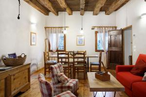 a living room with a red couch and a table at Villa Il Cortivo 81 in Fratta