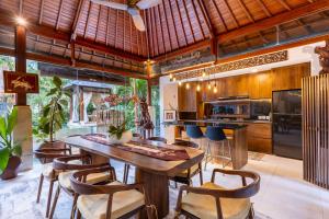 a kitchen with a wooden ceiling and a table and chairs at Villa Sulastri - Tanah Lot in Tanah Lot