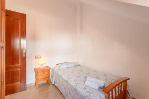a bedroom with a bed and a night stand with a lamp at Apartamento Valle de Abdalajis in Málaga