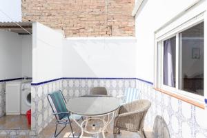 a patio with a table and chairs and a window at Apartamento Valle de Abdalajis in Málaga +14 photos