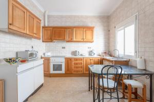 a kitchen with wooden cabinets and a table with chairs at Apartamento Valle de Abdalajis in Málaga