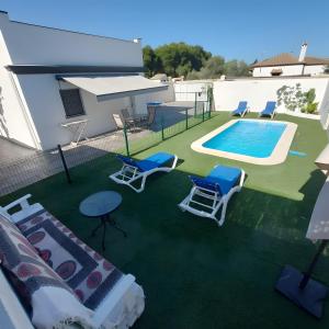 a backyard with a swimming pool and chairs and a table at Casa Alex 1 in Zahora