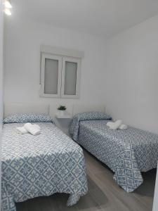 two beds in a room with white walls at Casa Alex 1 in Zahora +11 photos