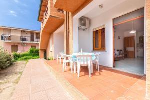 a table and chairs on the patio of a house at House Leoni in Isola Rossa