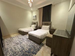 a hotel room with two beds and a desk at شقة المطيري in Jeddah