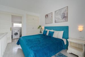 a bedroom with a blue bed and a washing machine at 1bed Duplex Las Americas in Playa de las Americas +14 photos