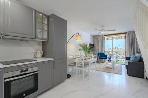 a kitchen and living room with a table and chairs at 1bed Duplex Las Americas in Playa de las Americas