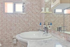 a bathroom with a white sink and a mirror at Pisos Leopoldo - Casaio in Casayo +44 photos