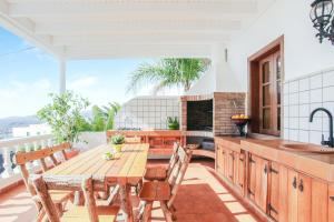 a kitchen with a wooden table and chairs on a balcony at Casa Salinoco in Mácher