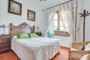 a bedroom with a bed with green pillows and a window at Casa Salinoco in Mácher +20 photos
