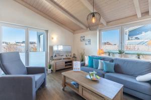 a living room with a blue couch and a table at Ferienhaus Stockente in Dagebüll