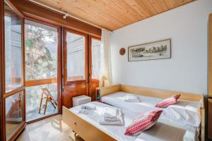 a bedroom with two beds and a window at Slalom 73 few Steps from Skiing - Happy Rentals in Bardonecchia