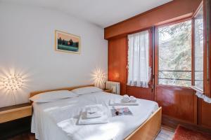 a bedroom with a bed and a large window at Slalom 73 few Steps from Skiing - Happy Rentals in Bardonecchia