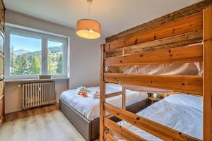 a bedroom with two bunk beds and a window at Starkeeper Apartment - Happy Rentals in Pragelato