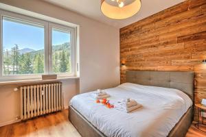 a bedroom with a bed with a wooden wall at Starkeeper Apartment - Happy Rentals in Pragelato