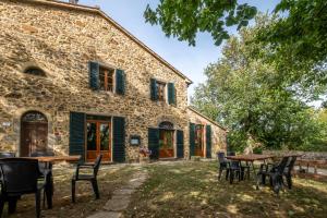 an external view of a stone house with tables and chairs at Oleandro in Arcidosso