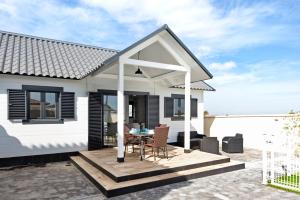 a white house with a patio with a table and chairs at Casa Manoli in Hozanejos