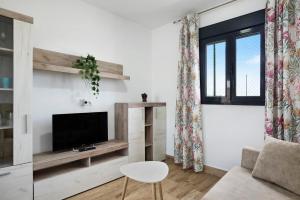 a living room with a tv and a couch at Casa Manoli in Hozanejos