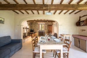 a dining room with a table and a couch at Appartamento Gemma Verde-tavoleto in Castiglione dʼOrcia