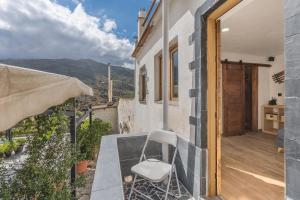 a white chair sitting on the balcony of a house at Apartamentos cuna del Genil in Güéjar-Sierra