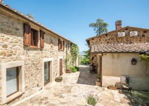 an external view of a stone house with a courtyard at Appartamento Gemma Verde-tavoleto in Castiglione dʼOrcia