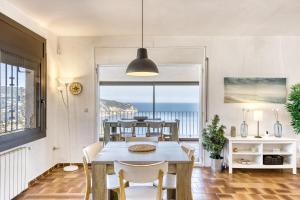 a dining room with a table and chairs and a view of the ocean at Casa Con Vistas Aiguablava in Tamariu