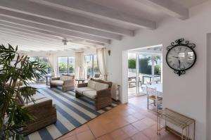 a living room with a clock on the wall at La Chamade Cala Dor in Santanyi