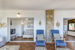 a living room with blue chairs and a couch at Casa Con Vistas Aiguablava in Tamariu