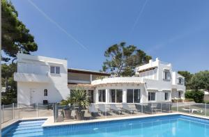 a large white house with a swimming pool at La Chamade Cala Dor in Santanyi