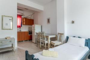 a room with a bed and a kitchen with a table at Perasma Studios 8 in Kipri