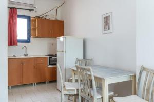a kitchen with a table and chairs and a refrigerator at Perasma Studios 8 in Kipri +14 photos