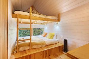 a bedroom with a bunk bed and a window at Cabanas do Alto da Coutada in Ponte de Lima