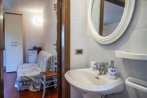 a bathroom with a sink and a mirror and a chair at Vecchio Molino in Gavorrano +72 photos