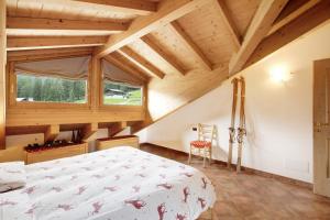a bedroom with a bed and a wooden ceiling at Casa Michela Mansarda in Valfurva