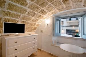 a room with a tv on a dresser and a window at Il Pescatore in Monopoli +13 photos