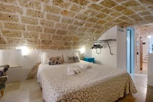 a bedroom with a bed with a stone wall at Il Pescatore in Monopoli